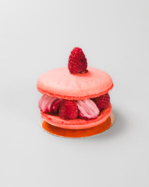 Macaron à la crème et aux framboises sur un fond gris