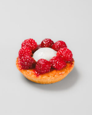 tartelette aux framboises avec crème vanille sur un fond gris