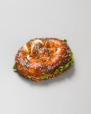 Bretzel avec salade et dinde sur un fond gris